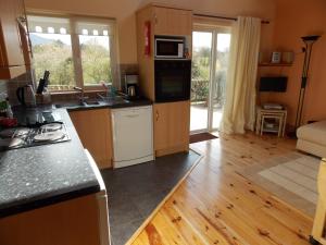 a kitchen with wooden cabinets and a counter top at Reads Park Self - Catering Accommodation in Galbally