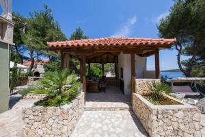 a patio with a wooden pergola on a house at Apartments Perla in Rukavac