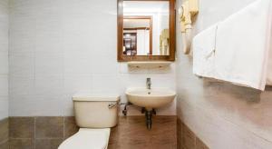 ein Badezimmer mit Toilette, Waschbecken und Spiegel in der Unterkunft Four Chain View Hotel in Singapur + 37 Fotos