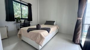 Un dormitorio blanco con una cama y una ventana. en Cha-emHouse1 Baantai, en Thong Sala