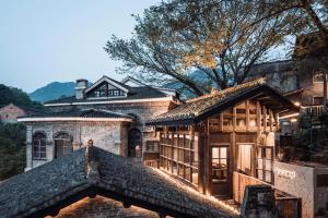 a house with a stone building with a roof at Futon Designer Hotel-Liberation Monument&Nanbin Road Store in Chongqing