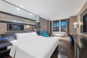 una camera da letto con un grande letto bianco e un bagno di Guangzhou Baiyun Airport Orange Crystal Hotel a Huadu