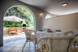 a dining room with a table and chairs and an umbrella at Apartments Perla in Rukavac