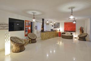 a lobby with chairs and a couch and a table at Oasis Tajaja Pousada in Jacumã