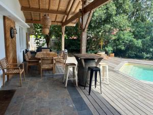 a deck with a table and chairs next to a pool at Villa Mauret Plage in Andernos-les-Bains
