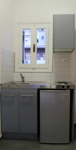 een keuken met een wastafel en een fornuis en 2 ramen bij Villa Nefeli in Batsi