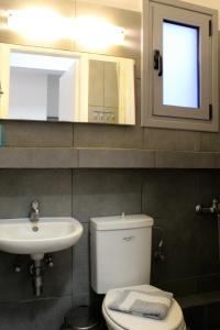 een badkamer met een wit toilet en een wastafel bij Villa Nefeli in Batsi +43 foto's