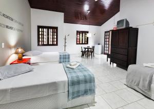 a bedroom with two beds and a dining room at Pousada Camury in Garuva +84 photos