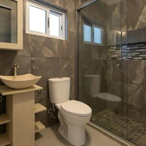 a bathroom with a toilet and a sink and a shower at Suites C O V A D O N G A in Mexico City