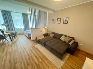 a living room with a couch and a table at Pretti Apartments - Neu, Stilvoll, Zentral, Komfortabel, Geräumig & Ruhig in Bamberg +17 photos