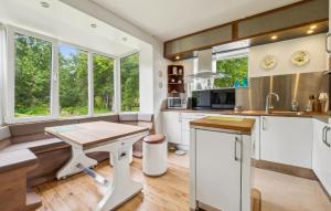 a kitchen with white cabinets and a wooden table at 3 Bedroom Lovely Home In Nykøbing M in Nykøbing Mors