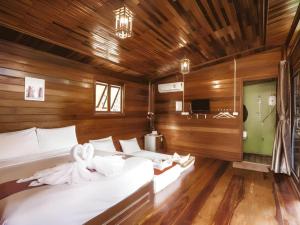 Ban Pha Saeng LangRiver View Resort At Chaewlan的一间木墙房间里有两张床