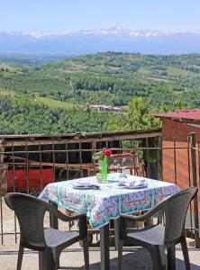 a table with two chairs and a vase of flowers on it at Agriturismo Al Brich in Albaretto Della Torre 