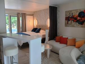 a bedroom with a bed and a living room with a couch at Studio Eik 105 at the pool in nature domain in Aan de Wolfsberg +42 photos