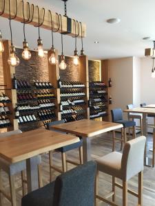 - une cave à vin avec des tables et des chaises ainsi qu'un casier avec des bouteilles de vin dans l'établissement Hotel Mont.Lac, à Champex-Lac