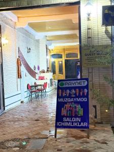 a sign on the front of a house with a patio at Avenue Guest House in Samarkand
