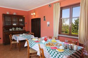 a dining room with two tables and a window at Agriturismo Al Brich in Albaretto Della Torre 