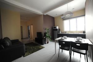 a kitchen and living room with a table and chairs at The Osborne Apartments in Ipoh