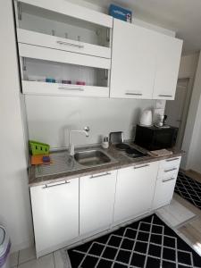 a kitchen with white cabinets and a sink at COZY CENTER Apartment Bihać in Bihać