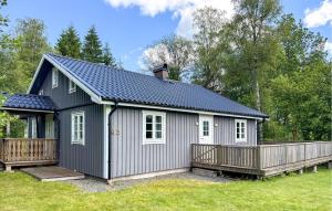 a grey shed with a porch and a fence at 3 Bedroom Pet Friendly Home In Nässjö in Nässjö +7 photos