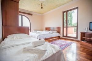 a bedroom with two beds and a tv and a window at Apartments Leonarda in Portorož