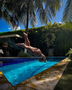 a person jumping into a swimming pool at Pousada Unaí in Porto De Galinhas +92 photos