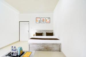 a white bedroom with a bed and a table at The Petra in Jaipur