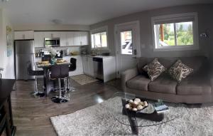 a living room with a couch and a kitchen at Cowichan Calling in Lake Cowichan