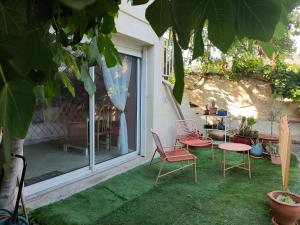 a patio with two chairs and a table and a window at Studio indépendant tout confort in Pujaut