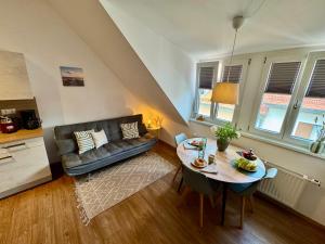 a living room with a table and a couch at Pretti Apartments - Modern eingerichtetes Apartment - mitten im Stadtzentrum in Bamberg