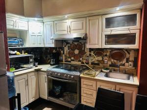 a kitchen with white cabinets and a stove top oven at El Encanto Residence in Morelia
