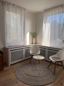 a room with two chairs and a table and two windows at Hotel Breuer in Hamm