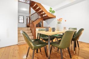 a dining room with a table and green chairs at 2-Bedroom House-Near city center Good for 6 Guests in Sydney