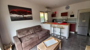 a living room with a couch and a kitchen at Un cocon de détente entre mer et nature in Zonza +7 photos