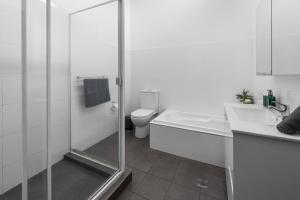 a bathroom with a shower and a toilet and a sink at 2-Bedroom House-Near city center Good for 6 Guests in Sydney +24 photos