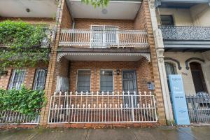 a brick house with a fence and a balcony at 2-Bedroom House-Near city center Good for 6 Guests in Sydney