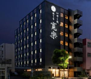 un edificio con un orologio su un lato di いやし処ほてる寛楽 久留米駅前 a Kurume