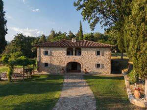 an external view of a stone house with a driveway at Villa Casale Chiesina in Bibbiena
