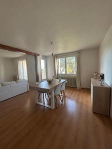 a living room with a table and a couch at appartement cosy tout équipé avec balcon in Châlette-sur-Loing