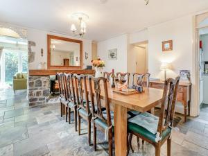 comedor y sala de estar con mesa de madera y sillas en Llys Aber, en Solva