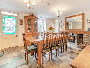 Un comedor con mesa y sillas de madera. en Llys Aber, en Solva