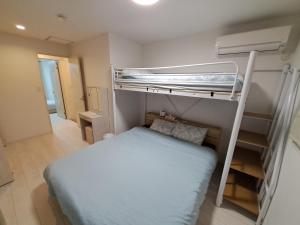 a bedroom with two bunk beds and a small bed at 旅路Hotel 住吉 in Fukuoka