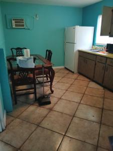 a kitchen with a table and a white refrigerator at GpL 5544 Cozy Getaway with Bright Colors & Full Kitchen in Fort Myers
