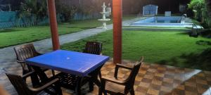 a blue table and chairs on a patio with a fountain at River view villa in Pondicherry