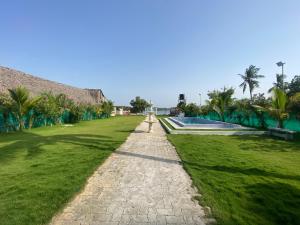 a path leading to a resort with palm trees at River view villa in Pondicherry
