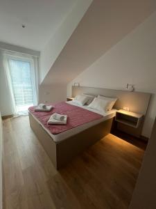 a bedroom with a bed with two towels on it at Petra & Vuk Apartments Kotor in Kotor