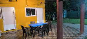 a blue table and chairs in front of a yellow house at River view villa in Pondicherry
