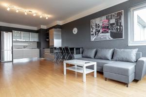 a living room with a couch and a table at Comfort & Views over Riga Apartment near Airport and City Center in Rīga