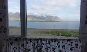 ein Fenster mit See- und Bergblick in der Unterkunft Námshestar in Kuludalsa