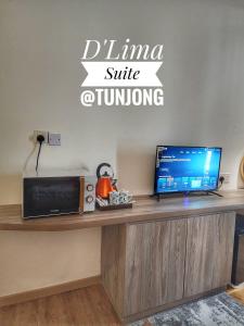 コタバルにあるD'Lima Suite at Tunjongのノートパソコンと電子レンジが置かれた机 +4枚の写真